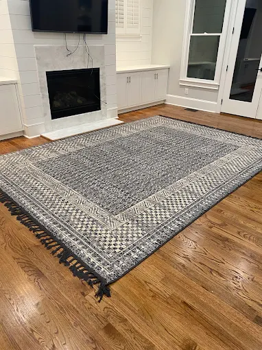 Freshly cleaned patterned area rug with fringe in a family living room